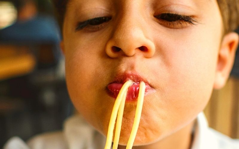 Dinner ideas for picky eaters - Boy enjoying plain pasta